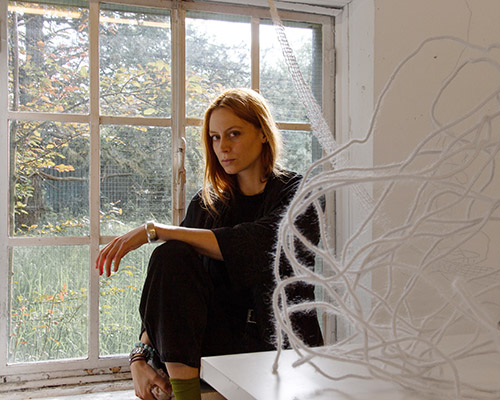 Eine junge Frau steht vor einem Büchertisch