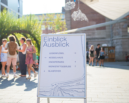 Eine Designerin sitzt auf einem Stuhl und hält ein Buch in den Händen