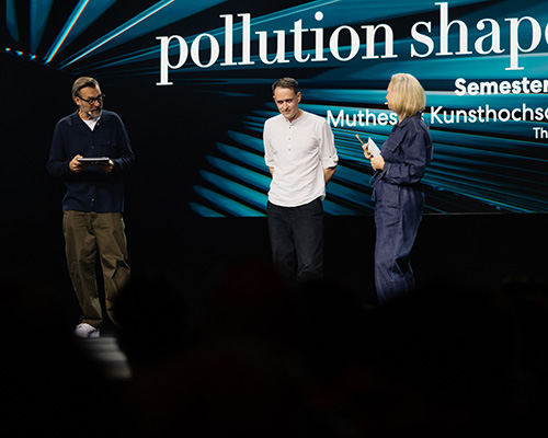 Drei Personen stehen auf einer Bühne im Rampenlicht