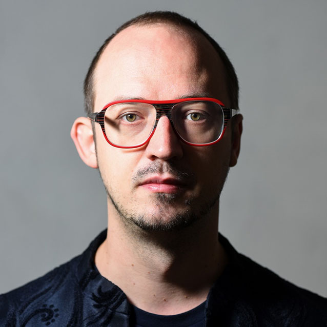 Eine Person im schwarzen Hemd posiert f&uuml;r die Kamera