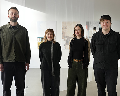 Vier Personen stehen in einem sonnendurchfluteten Ausstellungsraum