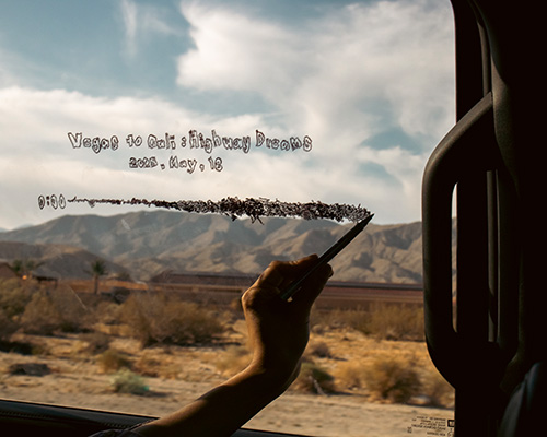 Zu sehen ist eine Hand, die mit einem Stift w&auml;hrend einer Autofahrt auf eine Fensterscheibe schreibt