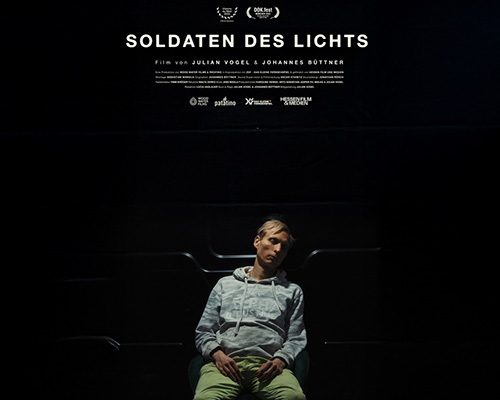 Zu sehen ist das Filmplakat - in einem schwarzen Raum sitzt eine Person mit geschlossenen Augen auf einem Stuhl