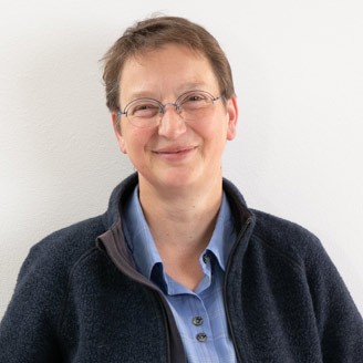 Portraitfoto einer Person, die in die Kamera l&auml;chelt