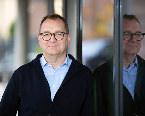 Portrait eines Mannes, der eine Brille und ein blaues Hemd trägt