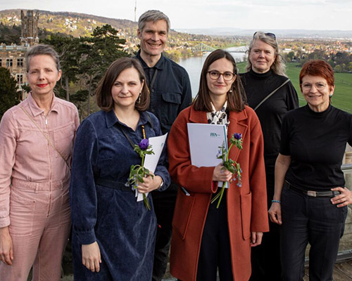 Eugenia Bakurin steht in einer Gruppe von Preisträgerinnen und Förderern sowie Juroren des Preises der Filmförderungsanstalt auf einem Balkon in Dresden.