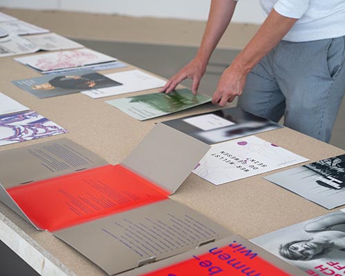 Eine Person arrangiert Bücher auf einem Ausstellungstisch